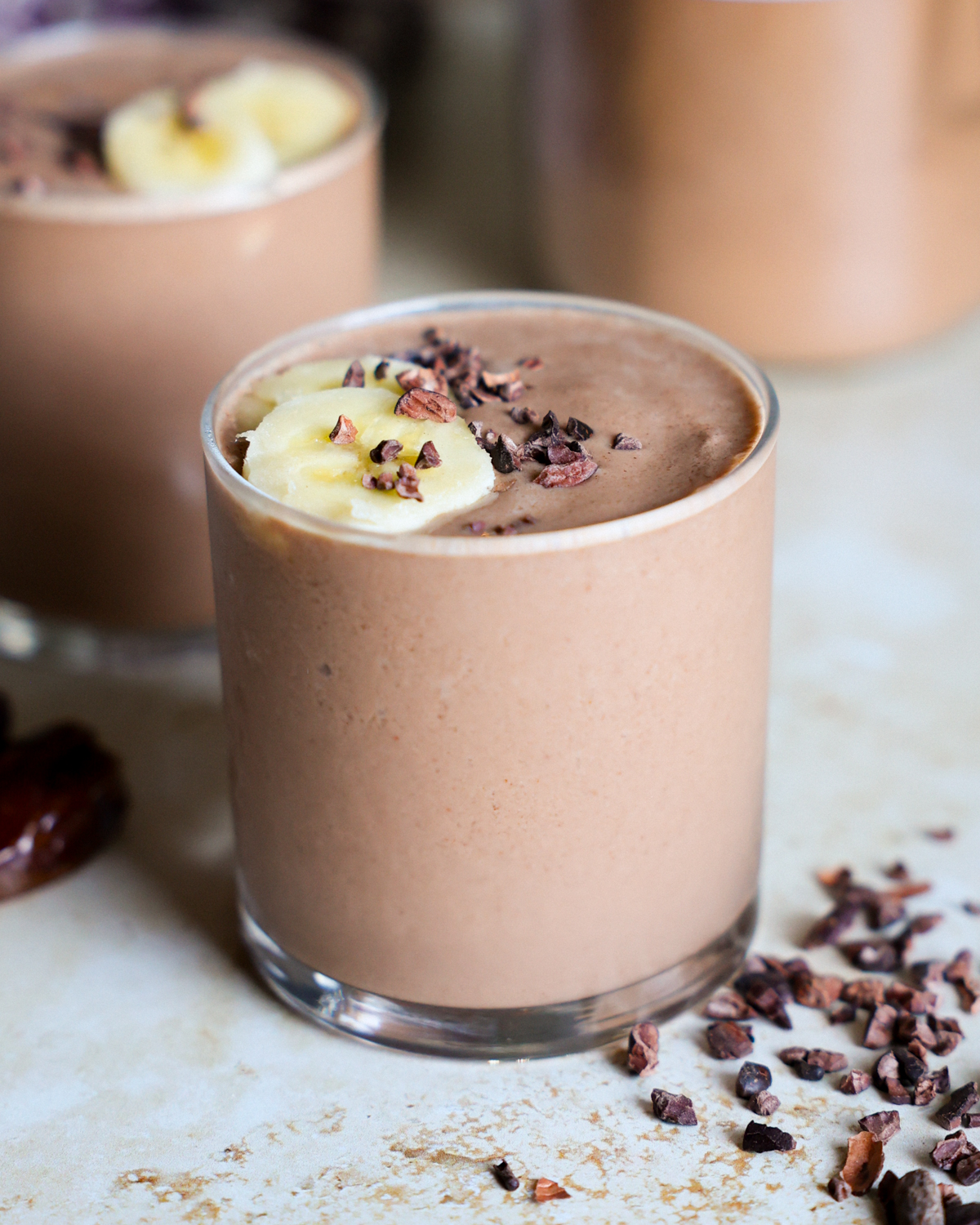 Smoothies in glasses on counter.