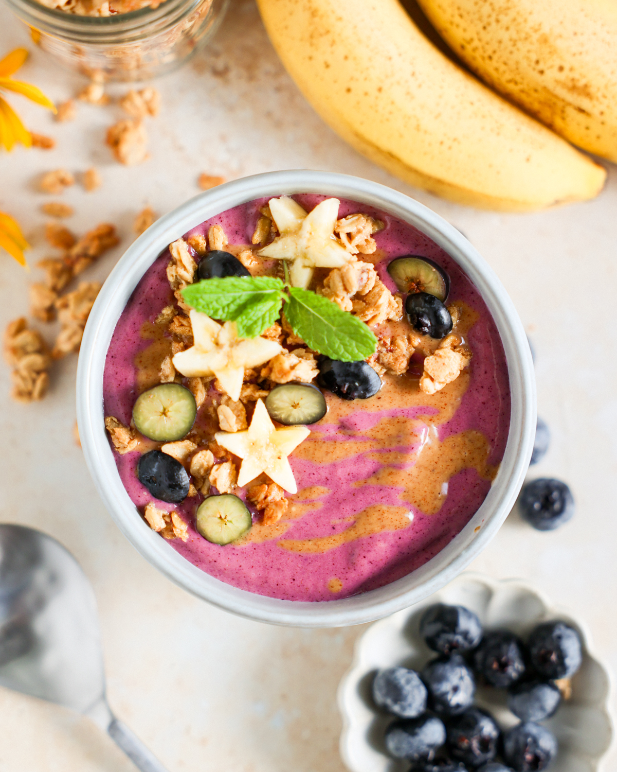 Berry smoothie bowl topped with fruit and granola.