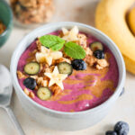 Smoothie bowl topped with fruit and granola.