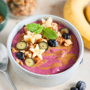 Smoothie bowl topped with fruit and granola.