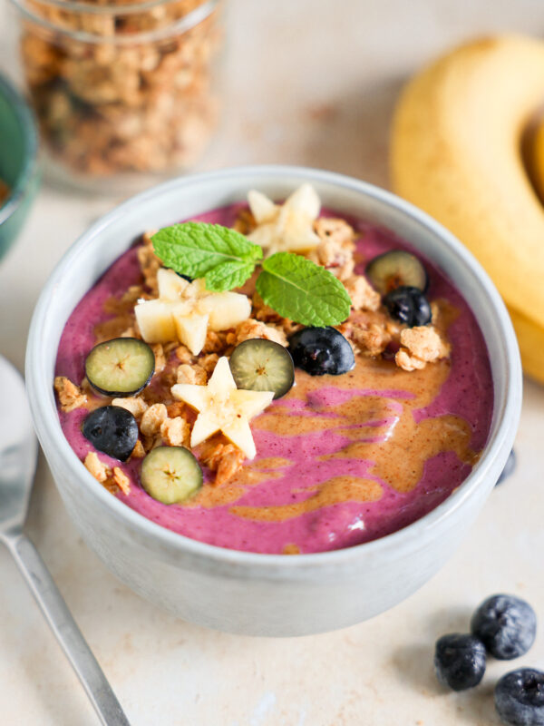 Smoothie bowl topped with fruit and granola.