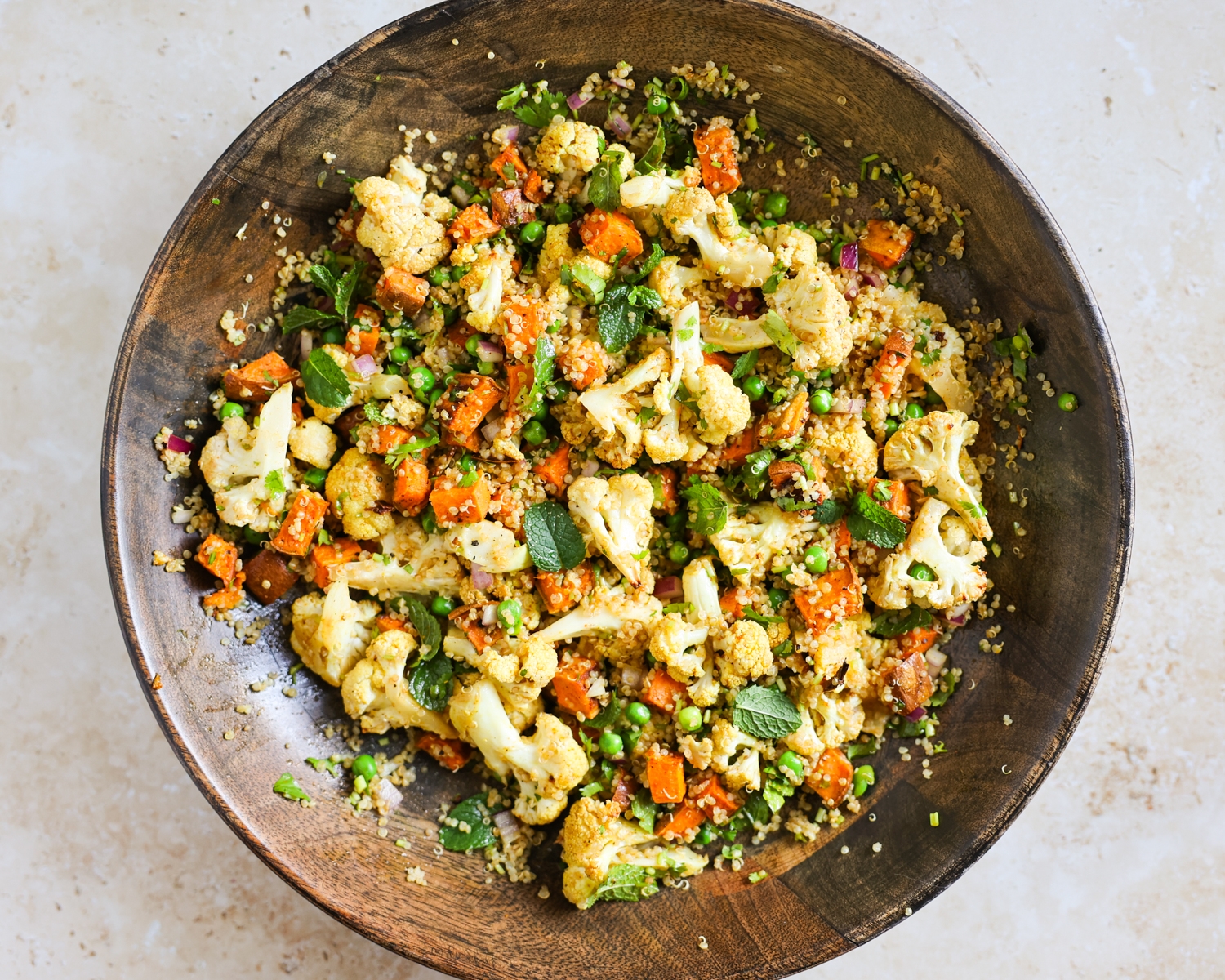 Roasted cauliflower and sweet potato salad in a large wooden salad bowl.